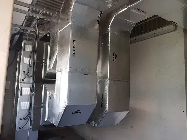 Una habitación con muchos tubos de metal colgando del techo.