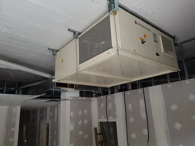 Una gran caja blanca cuelga del techo de una habitación.