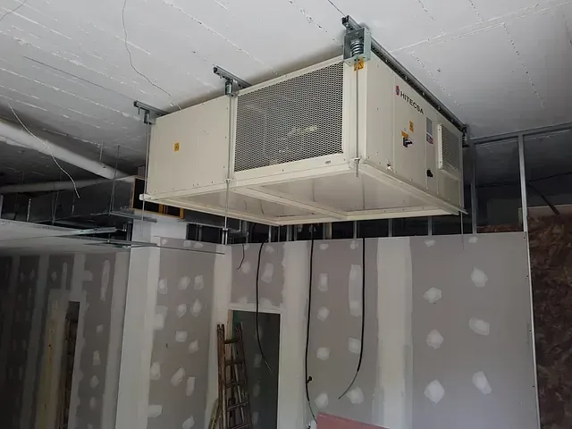 Una caja blanca cuelga del techo de una habitación.