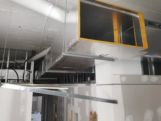 Un gran conducto cuelga del techo de un edificio en construcción.