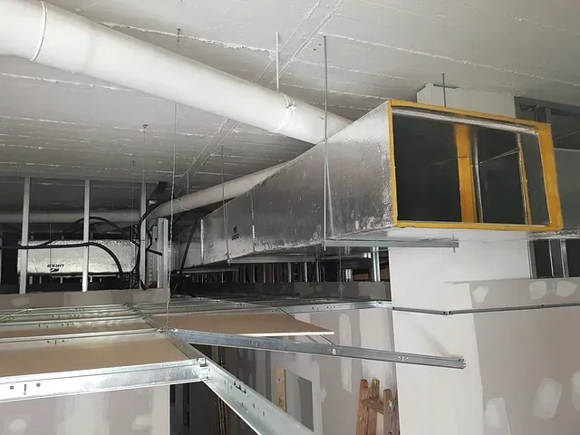 Una habitación con muchas tuberías colgando del techo.