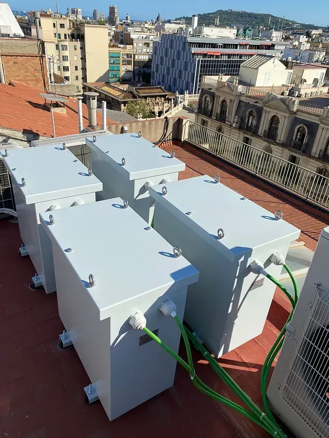 Una fila de cajas blancas están colocadas encima de un techo.
