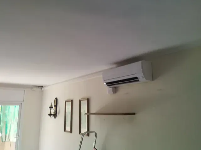 Una habitación con un ventilador de techo y una escalera en la pared.