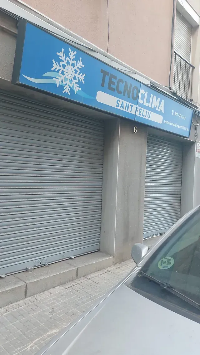 Un coche está aparcado delante de una tienda que está cerrada.