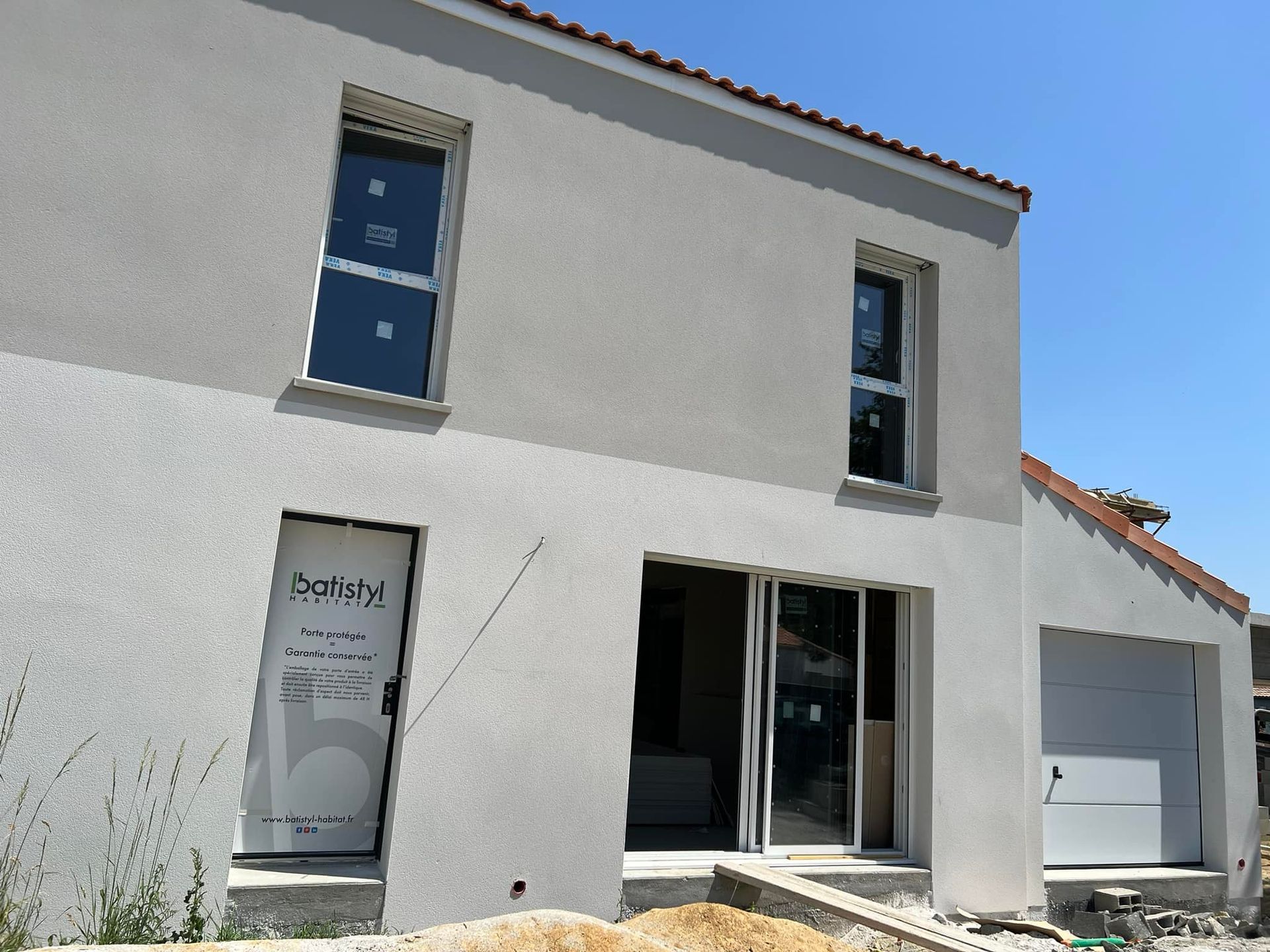 Pose d'enduit en deux teintes pour une façade d'une maison