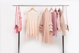 Pastellfarbene Oberteile auf einer Kleiderstange