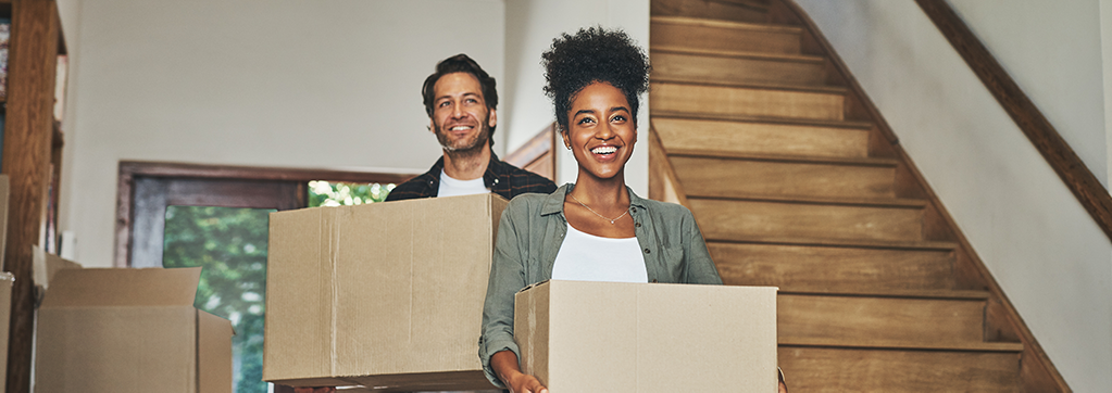 Couple heureux avec des cartons dans les bras