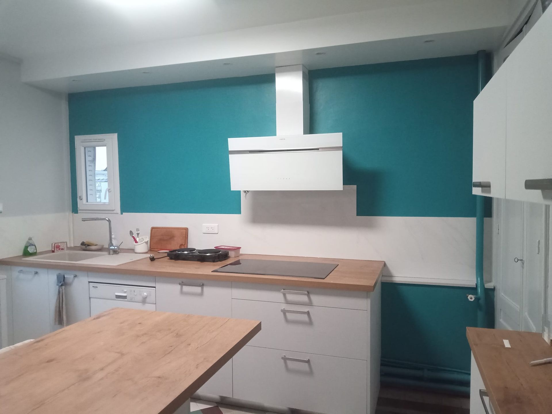 Une hotte de cuisine vue de face accrochée au plafond