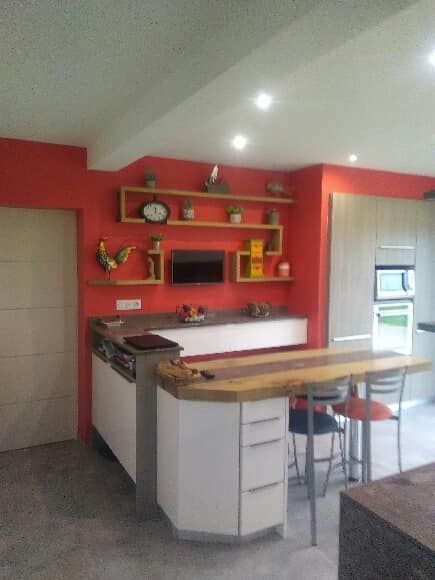 Un comptoir de cuisine blanc avec un tabouret rangé près de ce comptoir