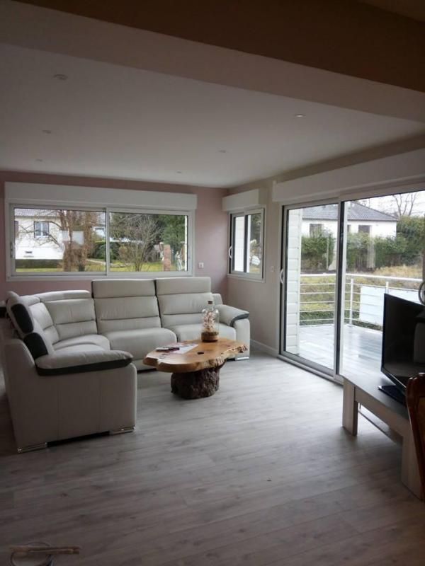 Un canapé vu de face posé au fond d'une pièce illuminée