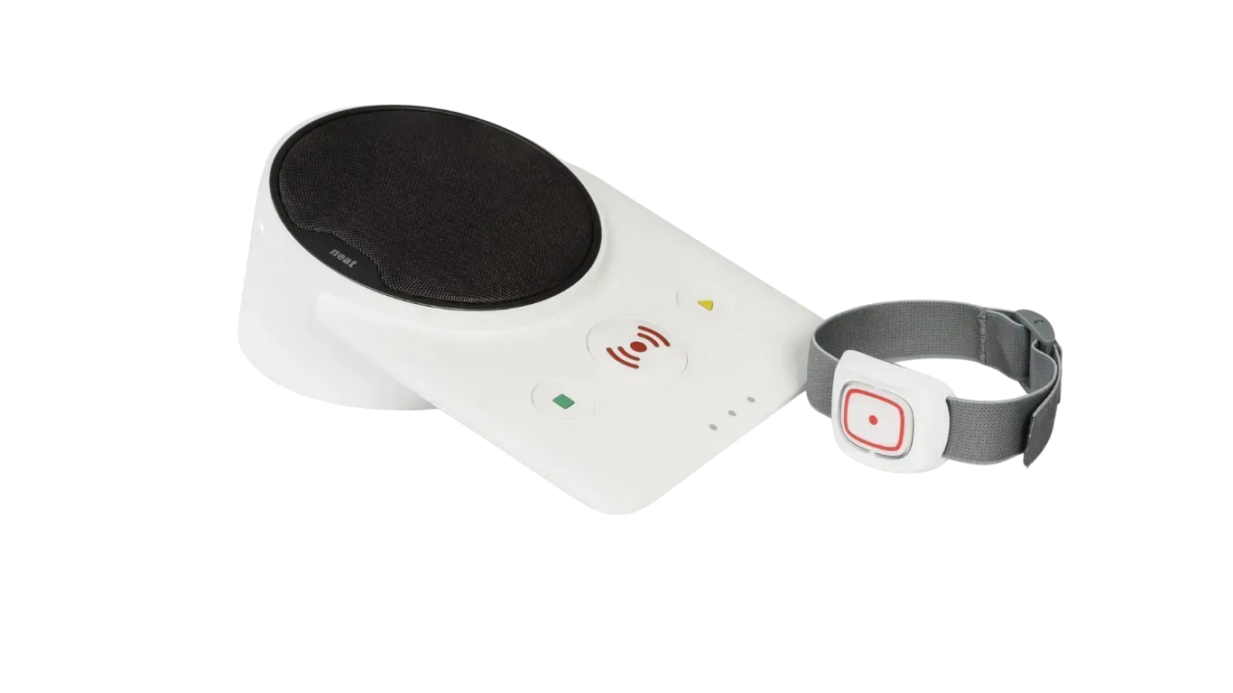 Une unité de base blanche avec un haut-parleur circulaire noir à côté d'un bracelet muni d'un bouton d'alerte rouge.