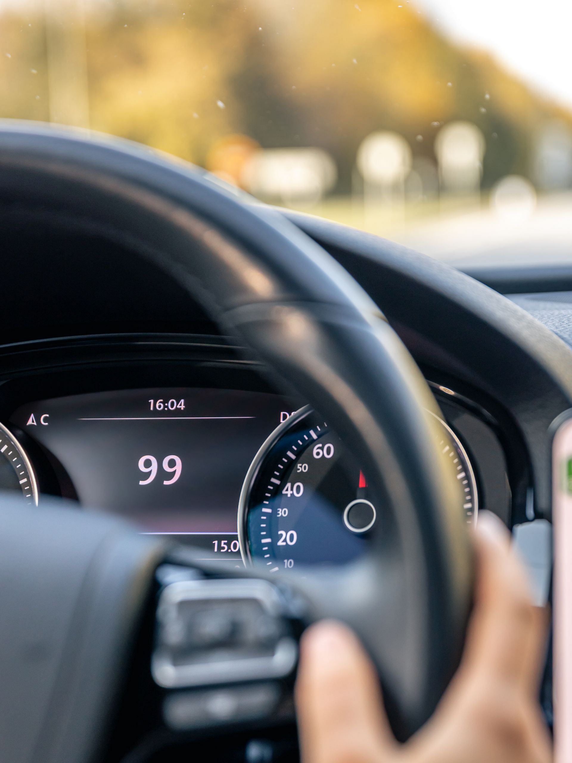 Vue du conducteur avec le tableau de bord. Les mains sur le volant, la route devant elle est floue.