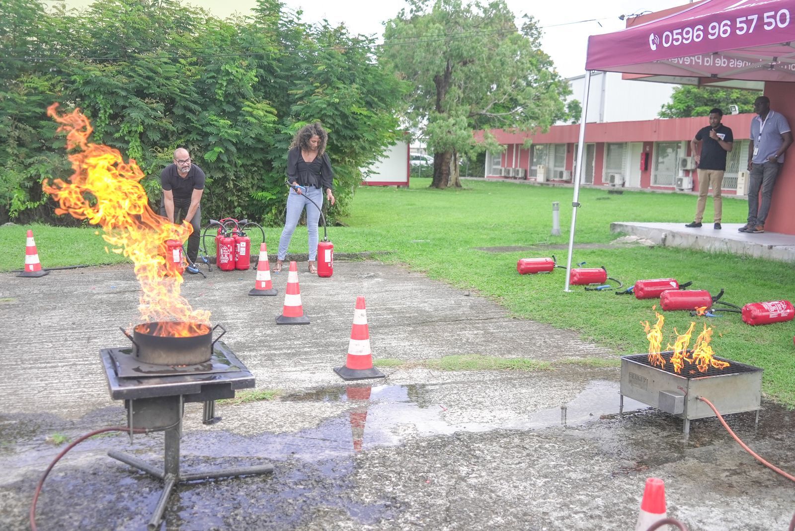 Personnes autour d'un foyer de feu avec plusieurs extincteurs tout autour