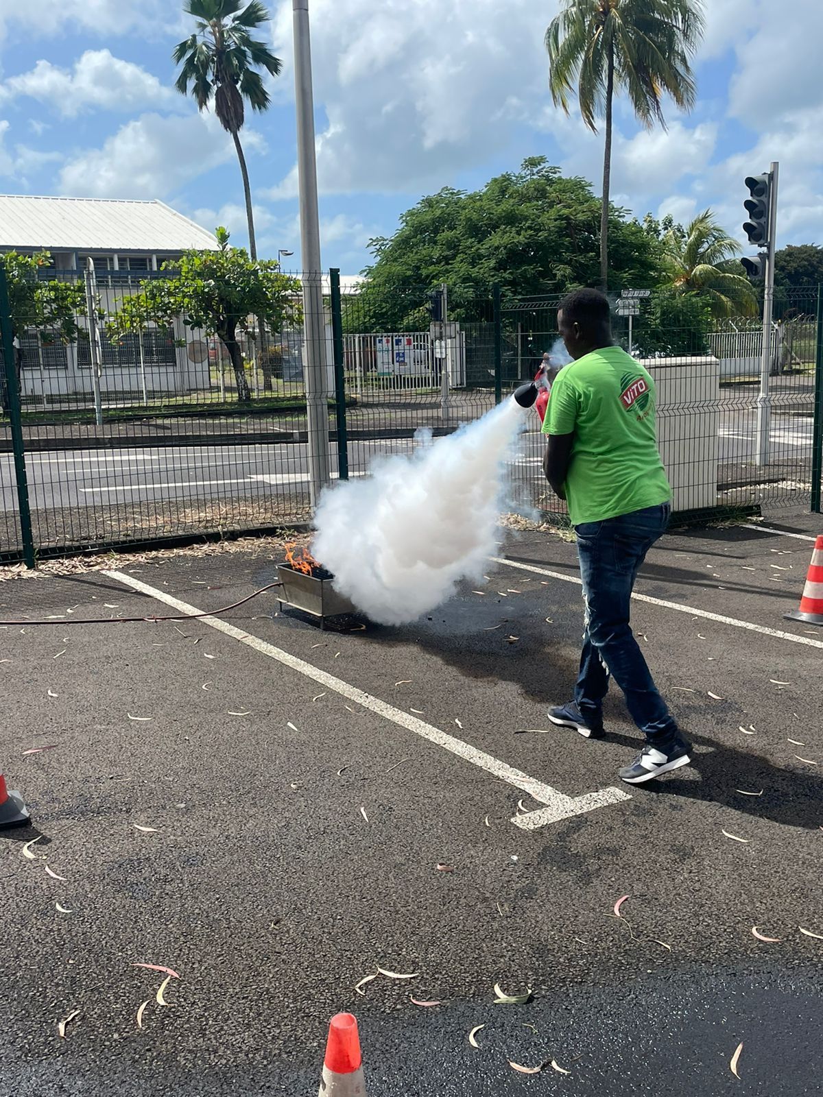 Employé en formation éteignant un feu avec un extincteur