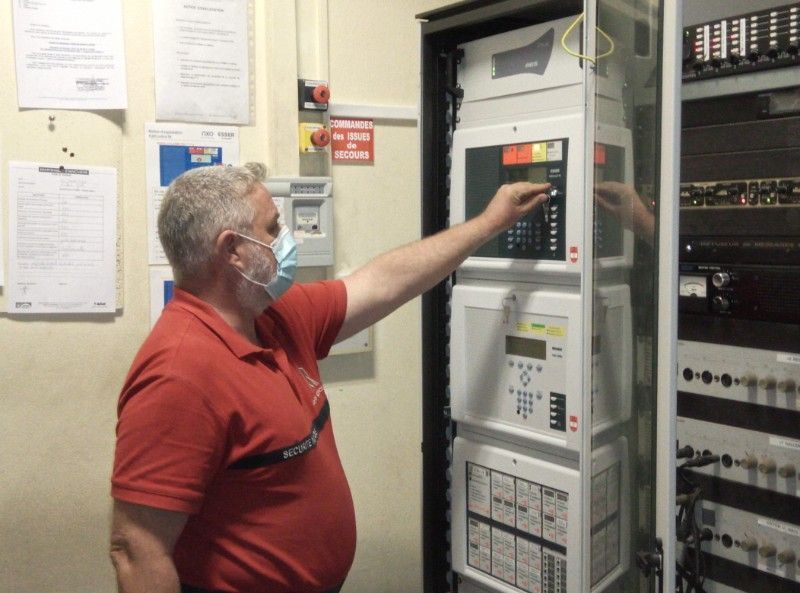 Une personne manipulant un système de sécurité incendie
