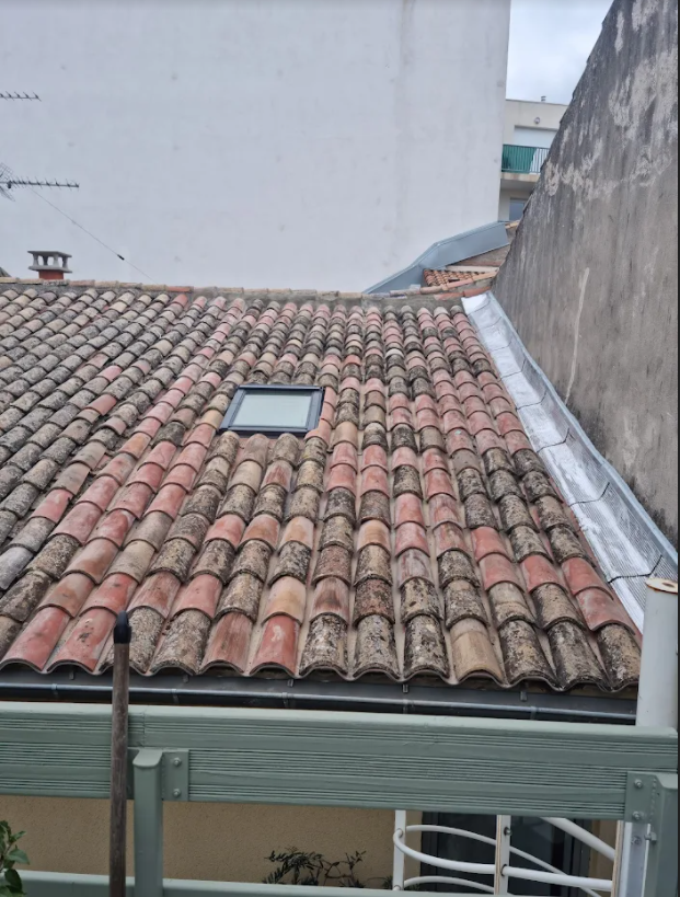 Fenêtre de toit installée sur une toiture à la couverture en tuiles