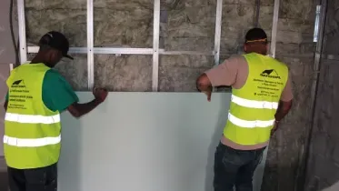 Um corredor com muito drywall nas paredes e no teto.