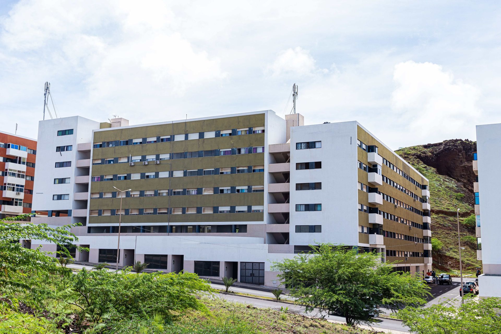 Um grande edifício com muitas janelas fica no topo de uma colina