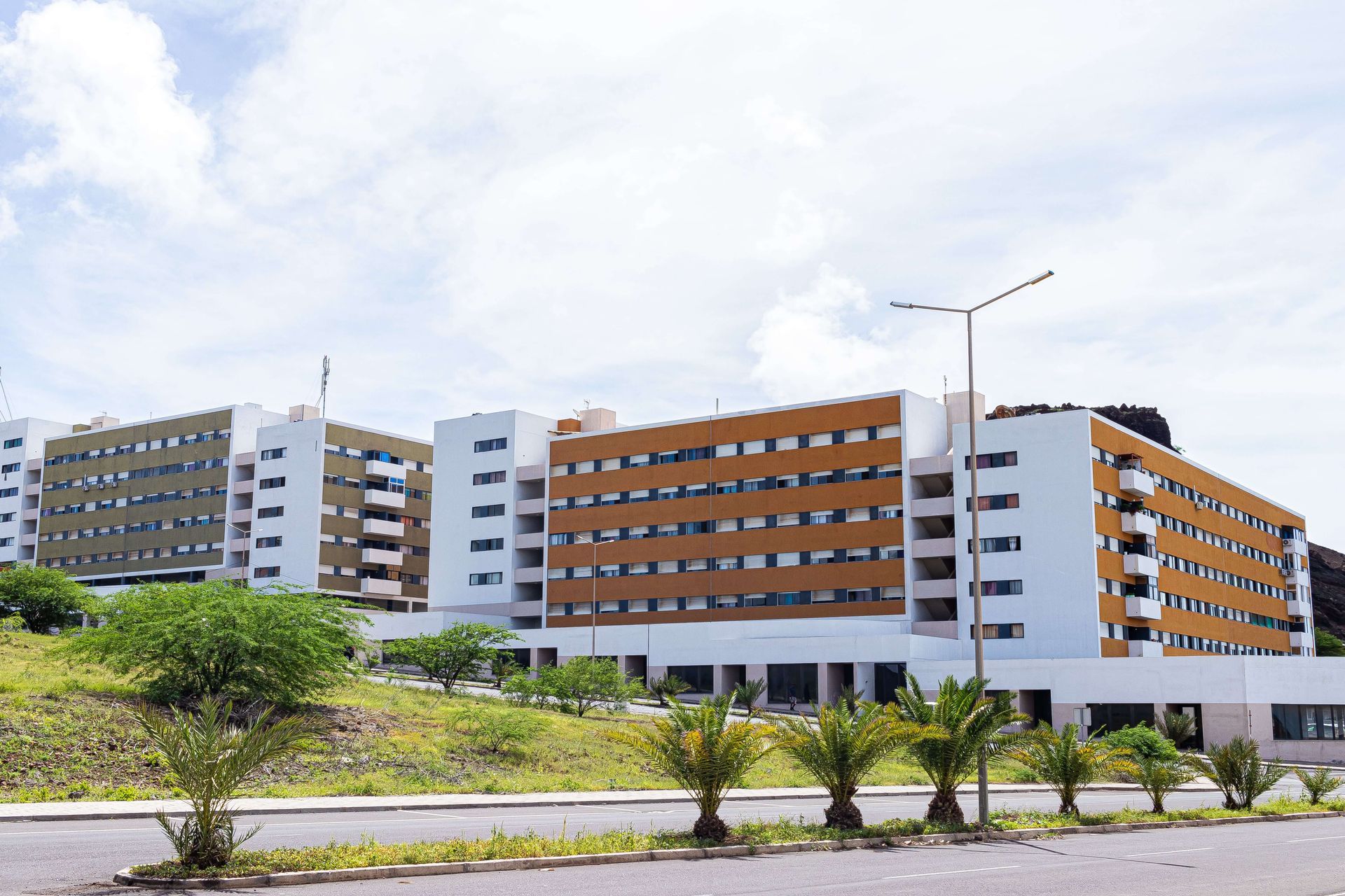 Um grande edifício com muitas janelas fica próximo a uma estrada