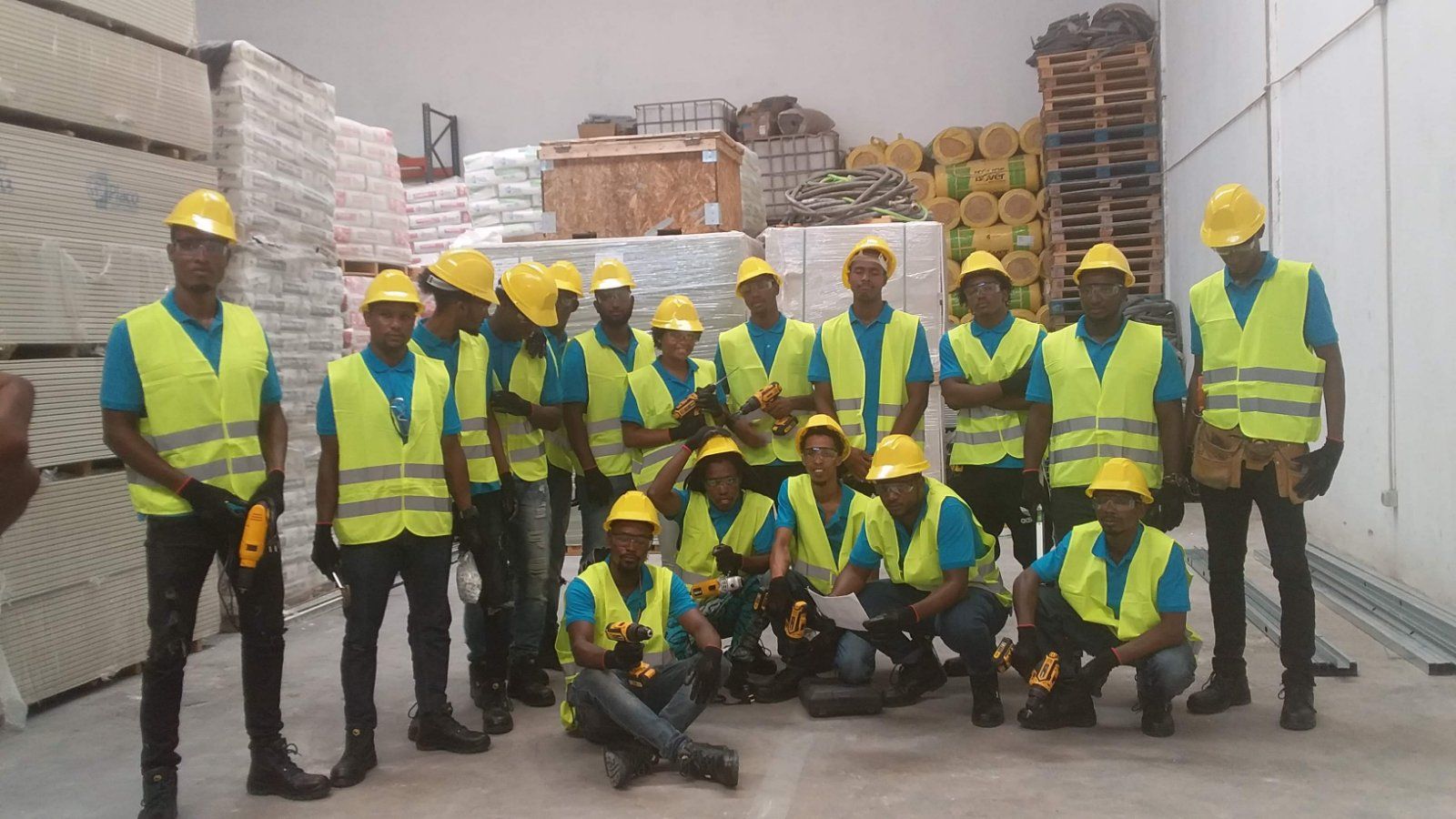 Um grupo de trabalhadores da construção civil posando para uma foto em um armazém
