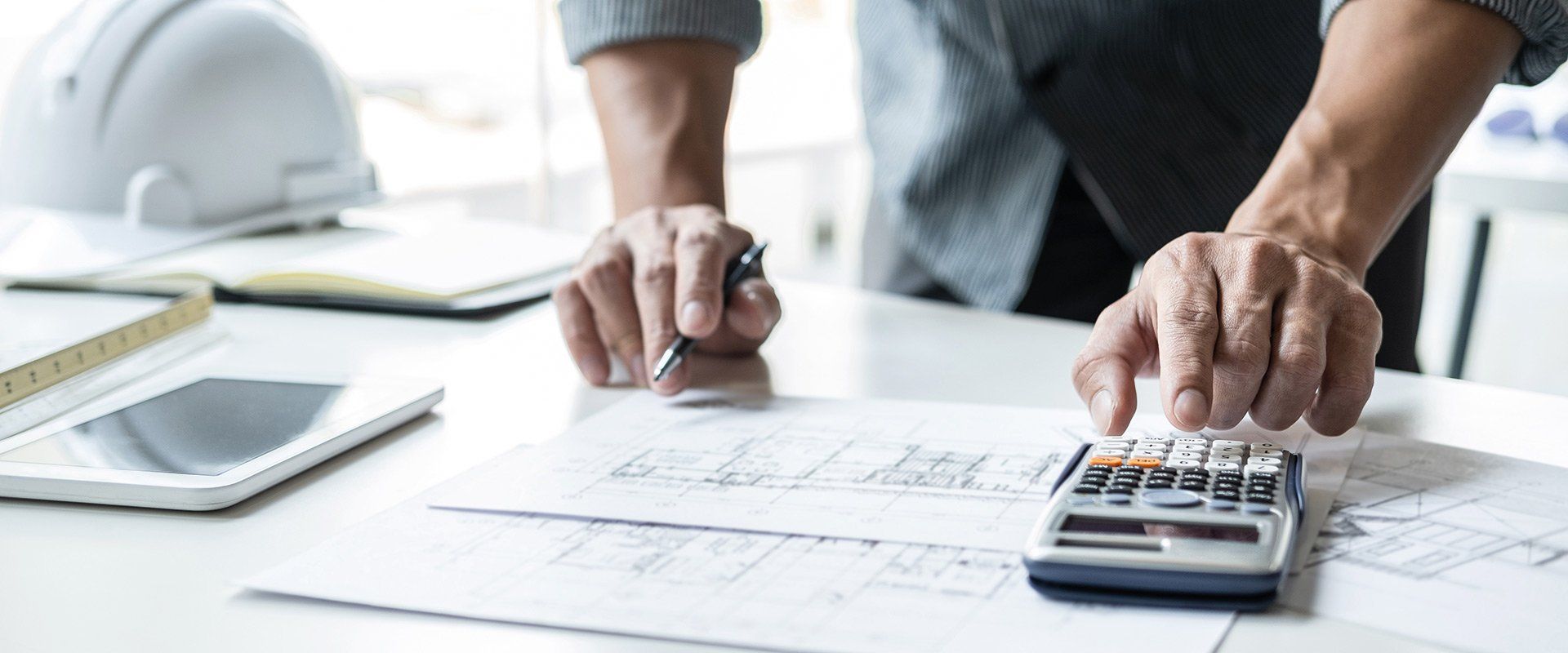 Expert en bâtiment rédige des notes sur un plan technique