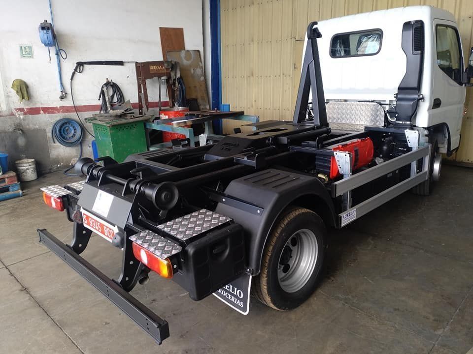 Un camión de basura blanco está estacionado en un garaje.