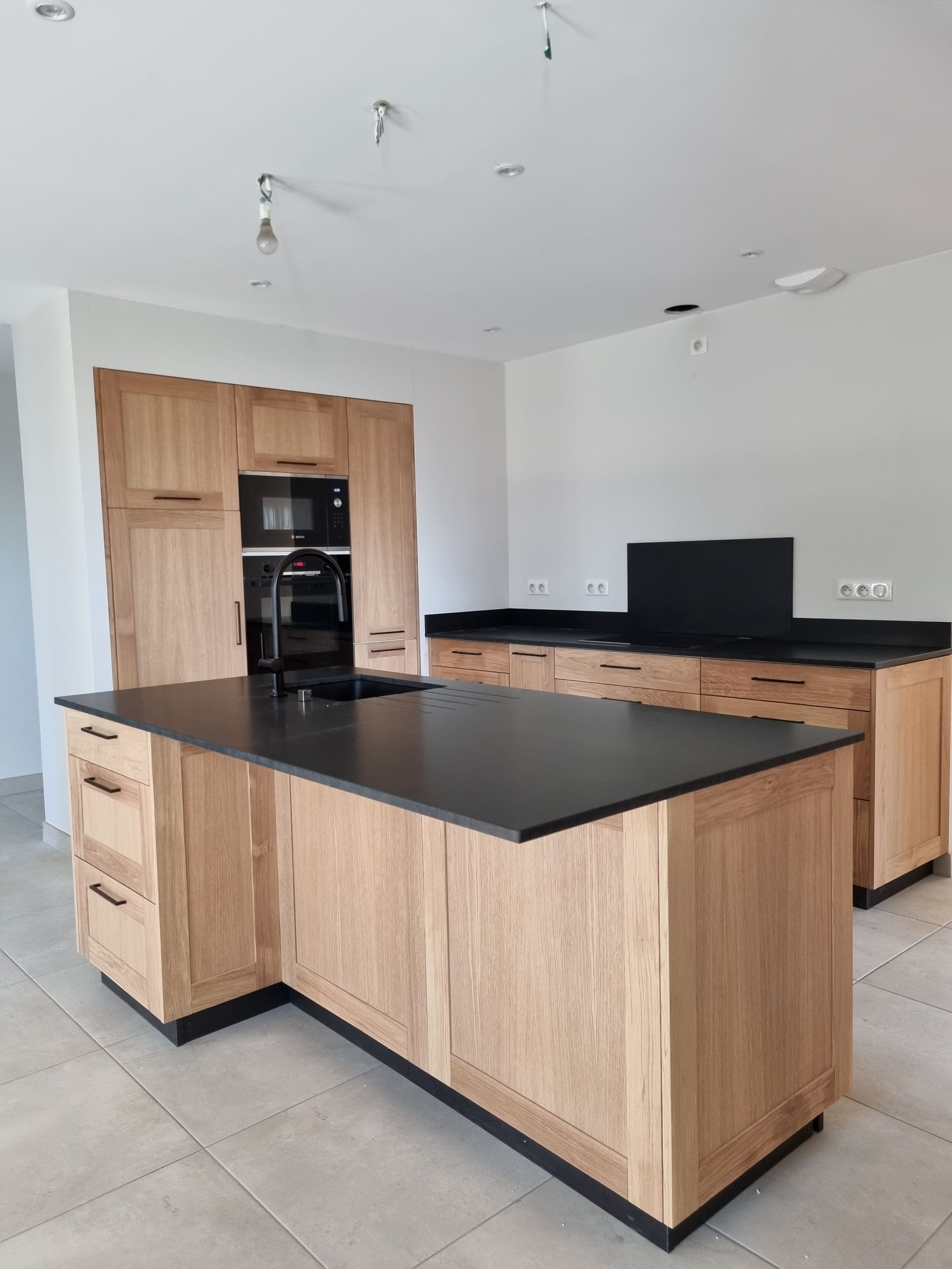 Cuisine revêtement bois avec plan de travail noir