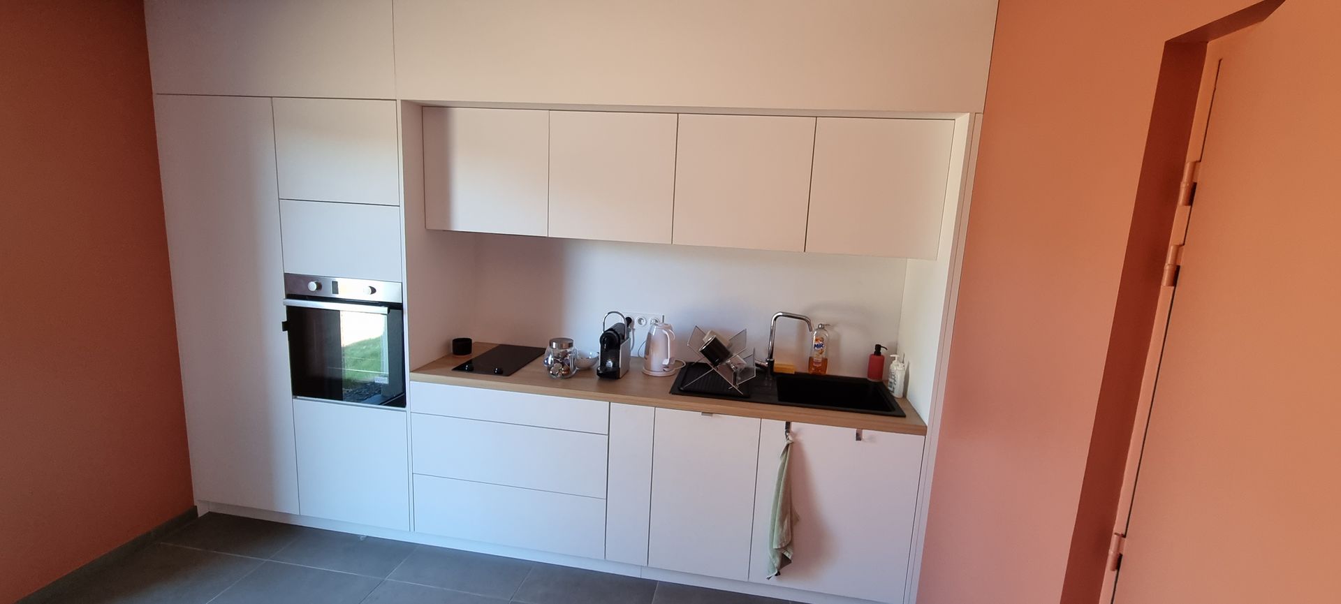 Cuisine blanche et murs couleur brique