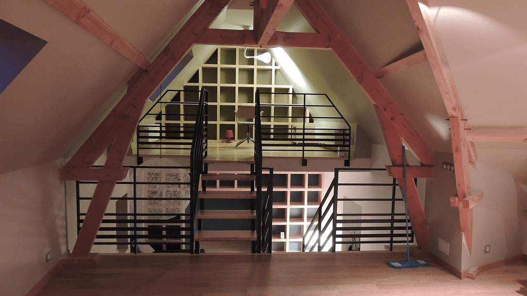 Mezzanine avec charpente apparente et escaliers en métal et bois
