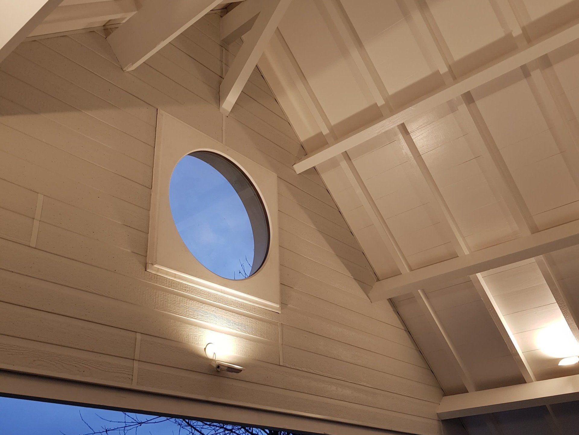 Fenêtre hublot et charpente blanche apparente