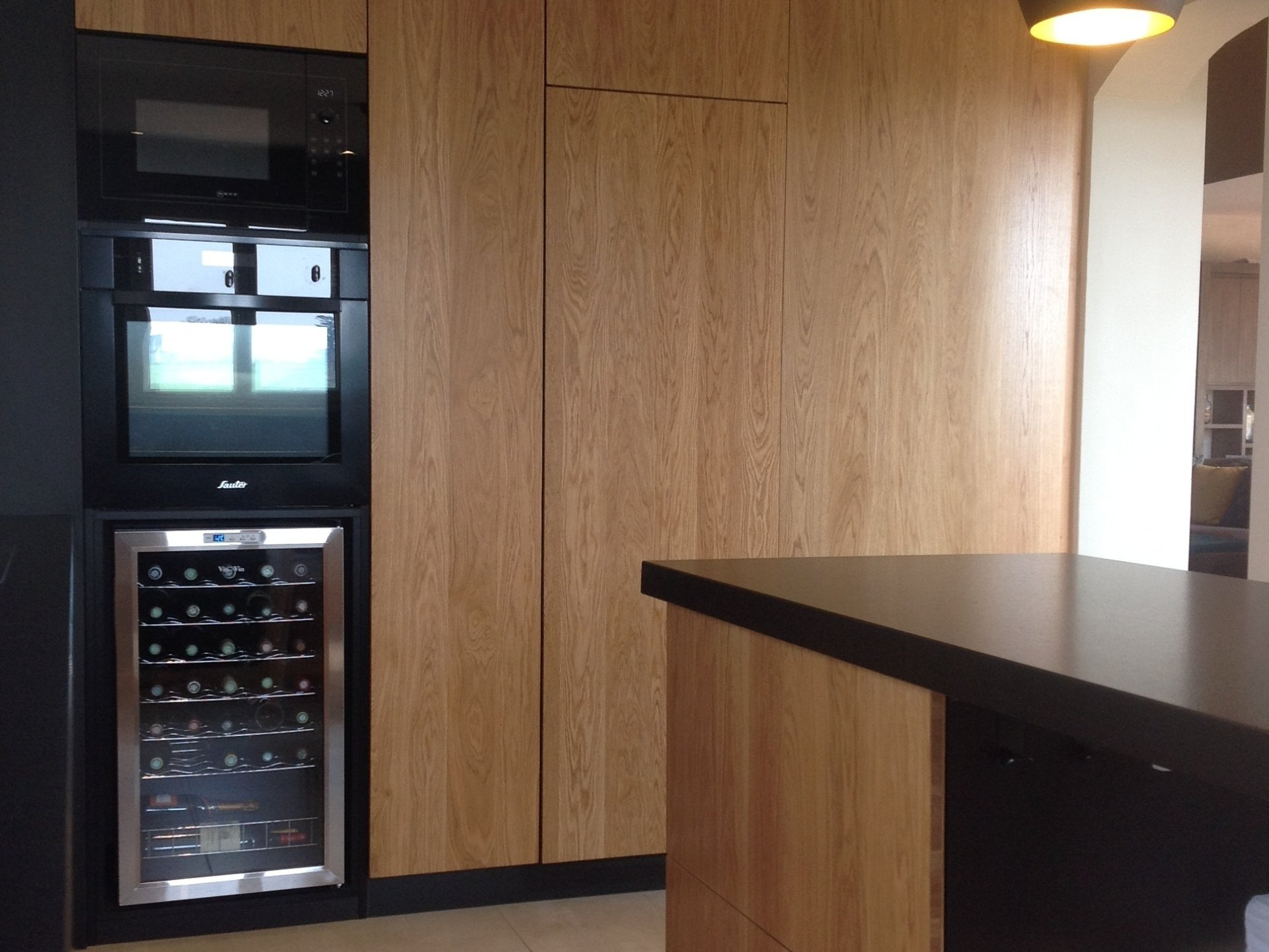 Cuisine aménagée avec revêtement effet bois et îlot central