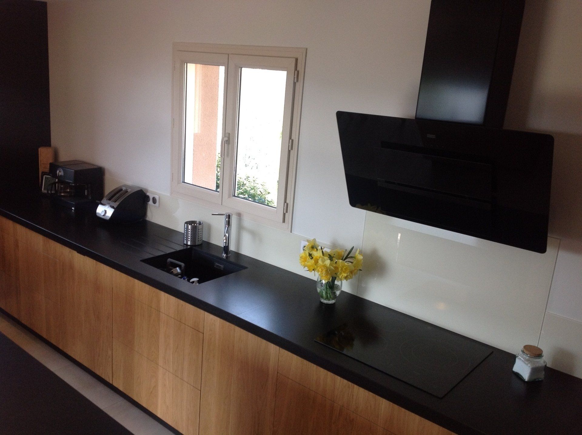 Cuisine revêtement en bois, plan de travail noir et hotte moderne