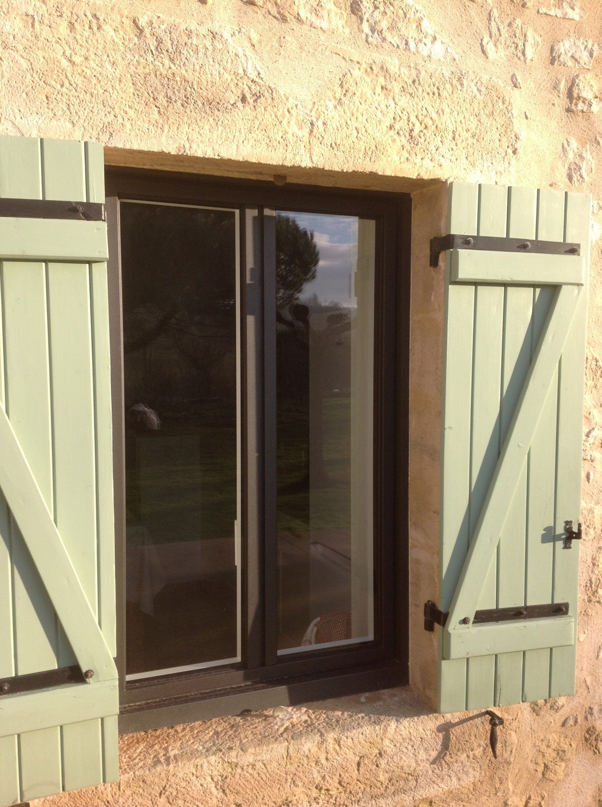 Fenêtre avec volet en bois peint en vert