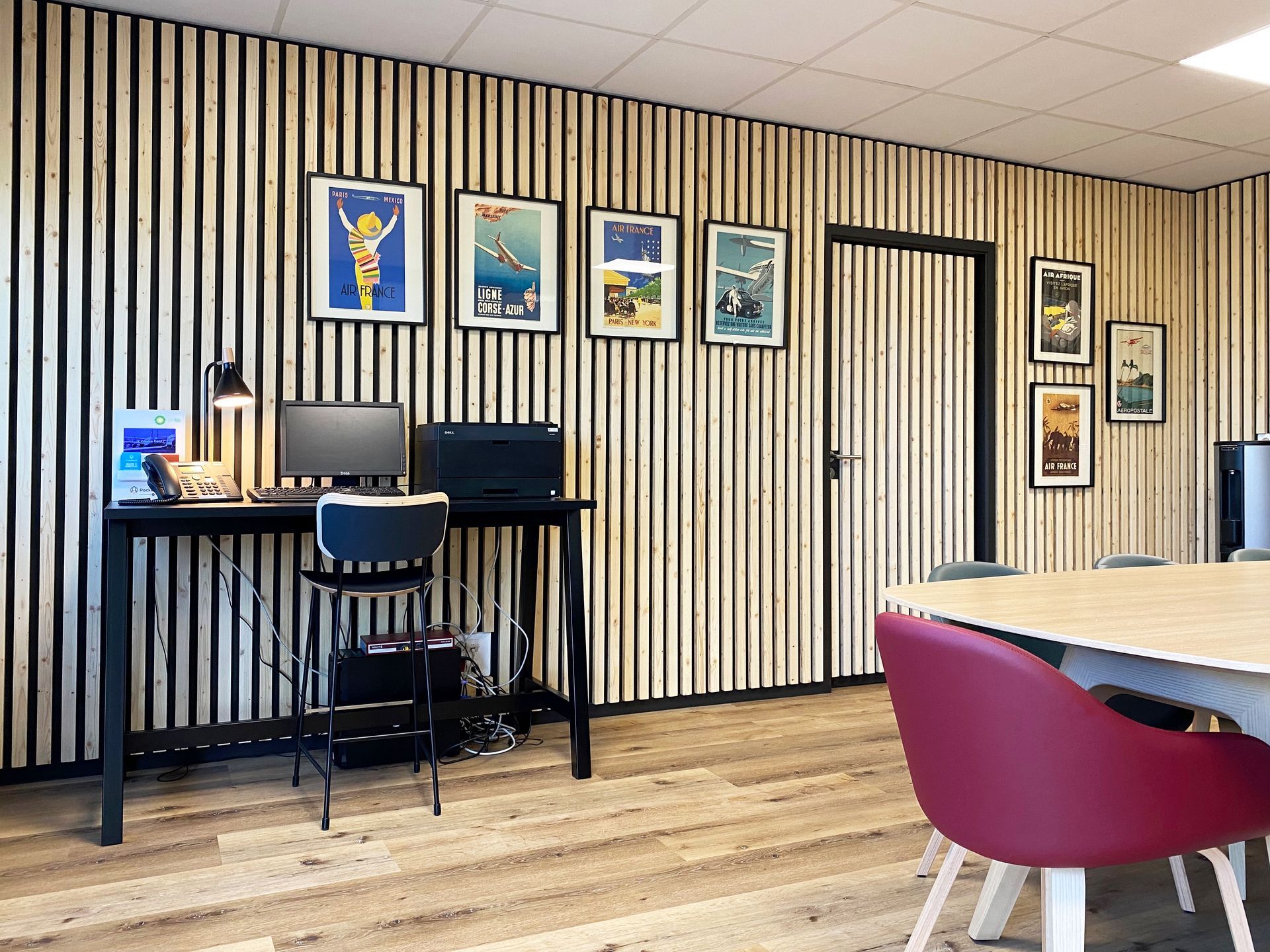Bureau avec table haute, table de réunion et mur habillé d'un bardage en bois