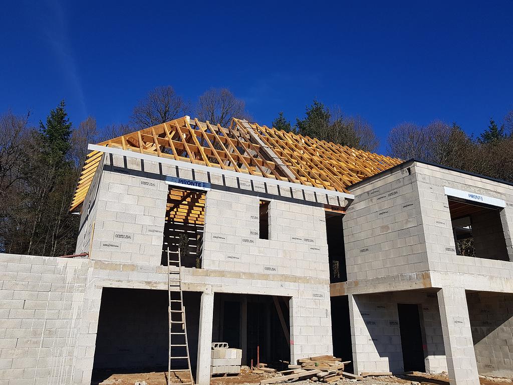 Maison à étage en parpaing en construction avec charpoente traditionnelle
