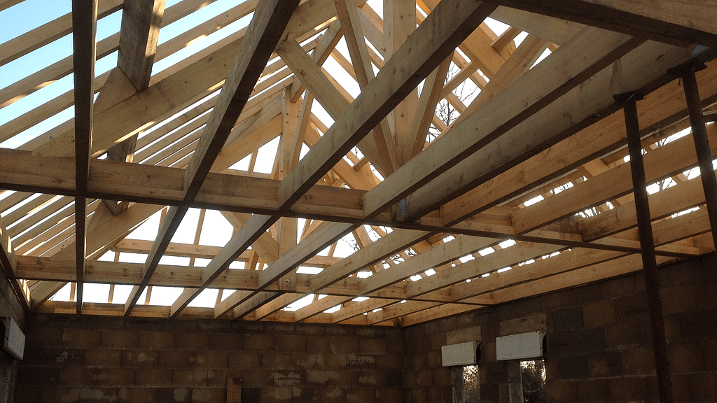 Maison en construction avec charpente en bois vue de l'intérieur