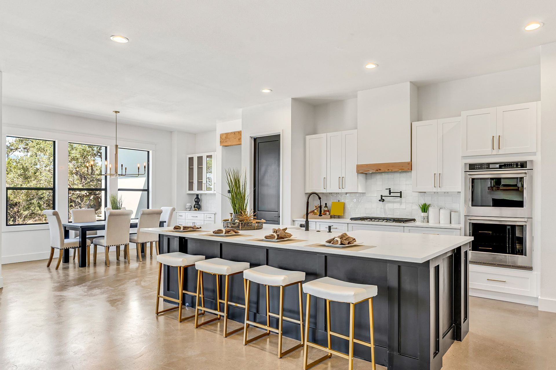 Moderne Küche mit weissen Schränken, einer grossen marineblauen Kochinsel mit vier Barhockern.