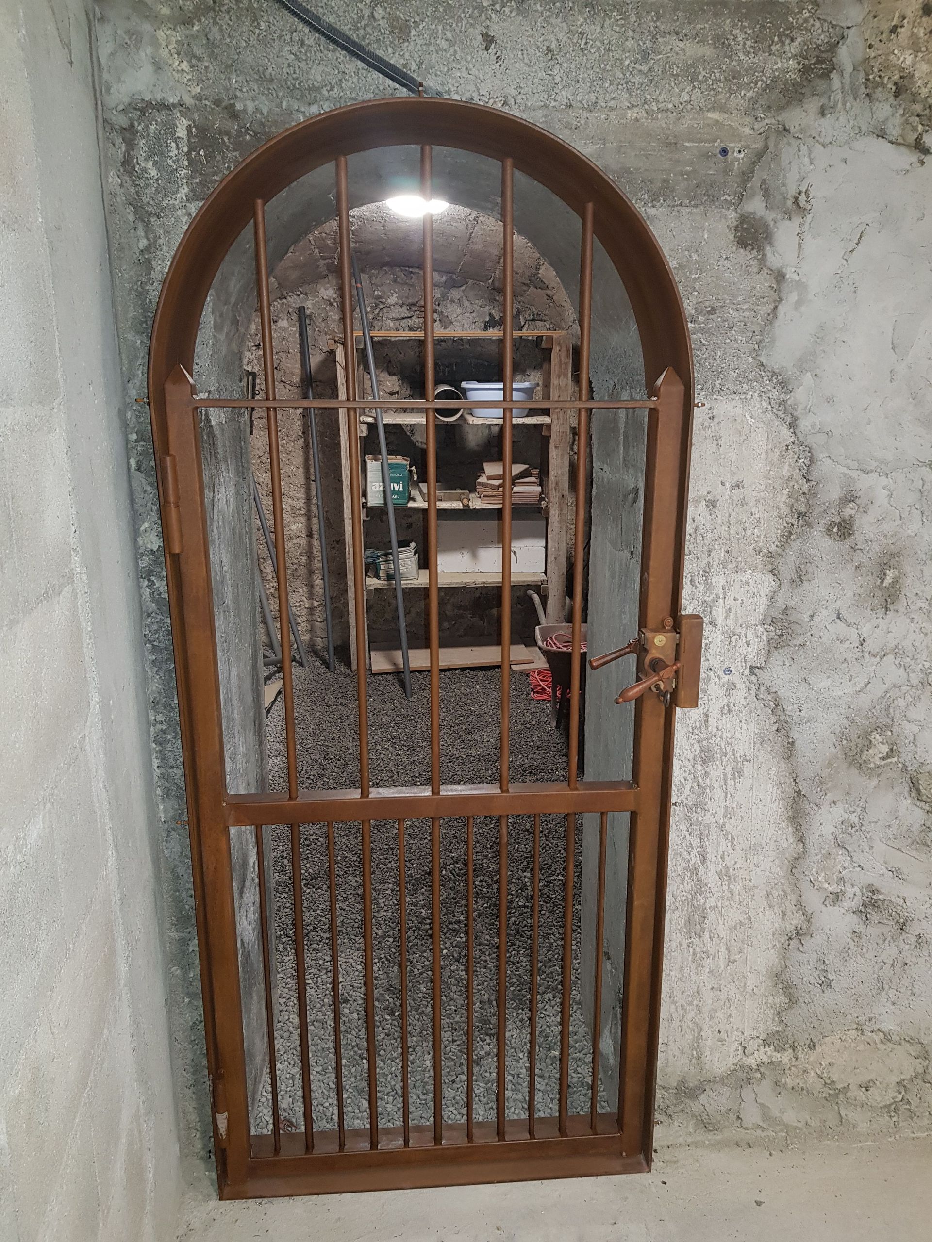 Porte métallique avec une grille, une poignée et un verrou