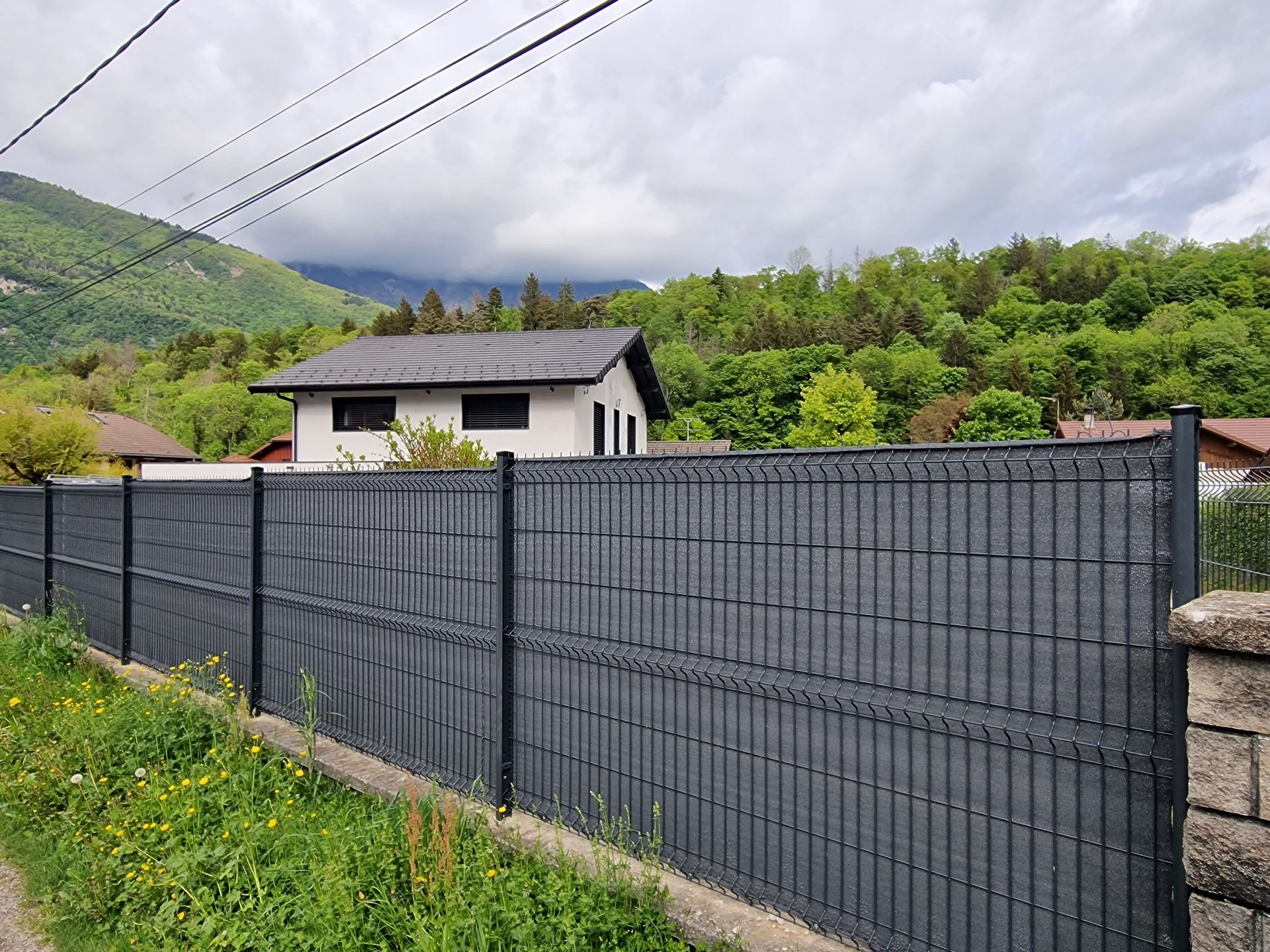 Pose de grilles métalliques avec un brise-vue entre deux jardins