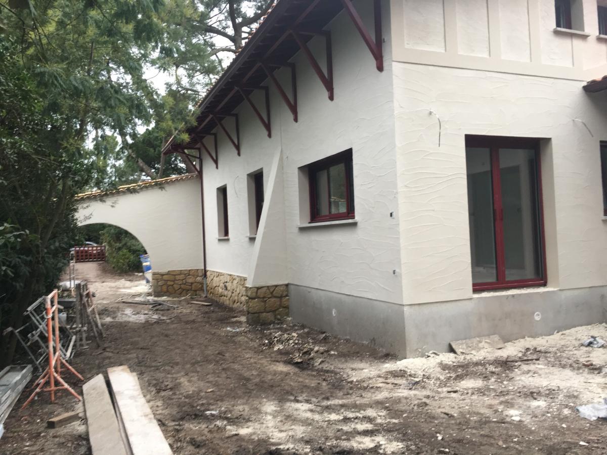 Facade blanche d'une maison en corus de réalisation 