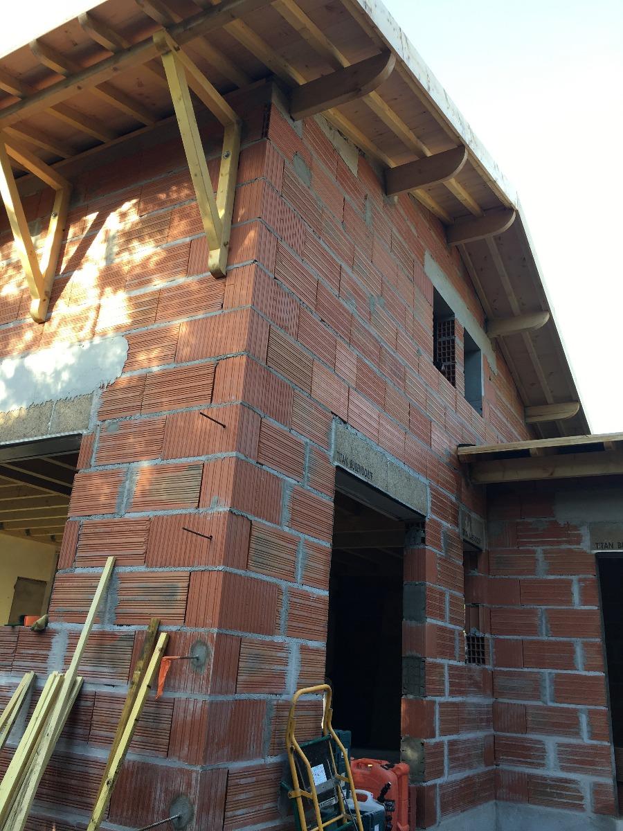 Construction d'une maison en brique avec un toit en bois 