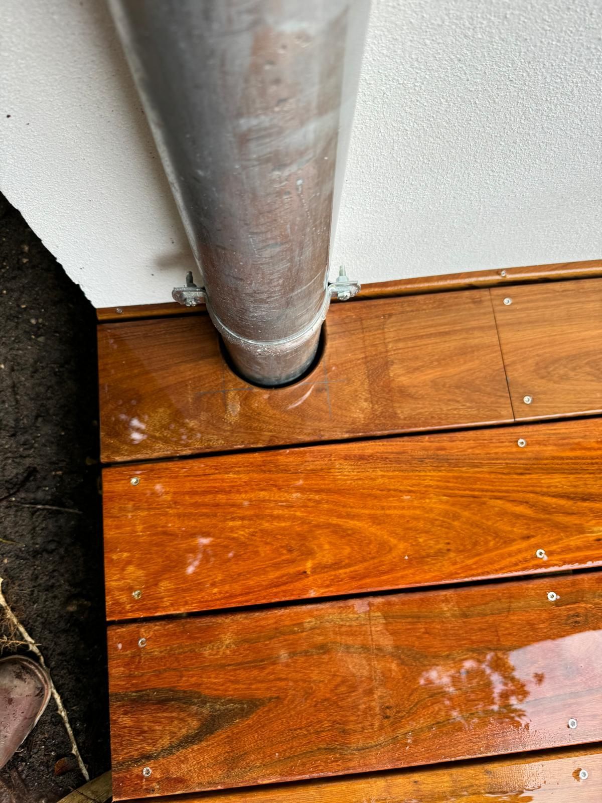 Passage du tuyau de descente de gouttières dans la terrasse en bois