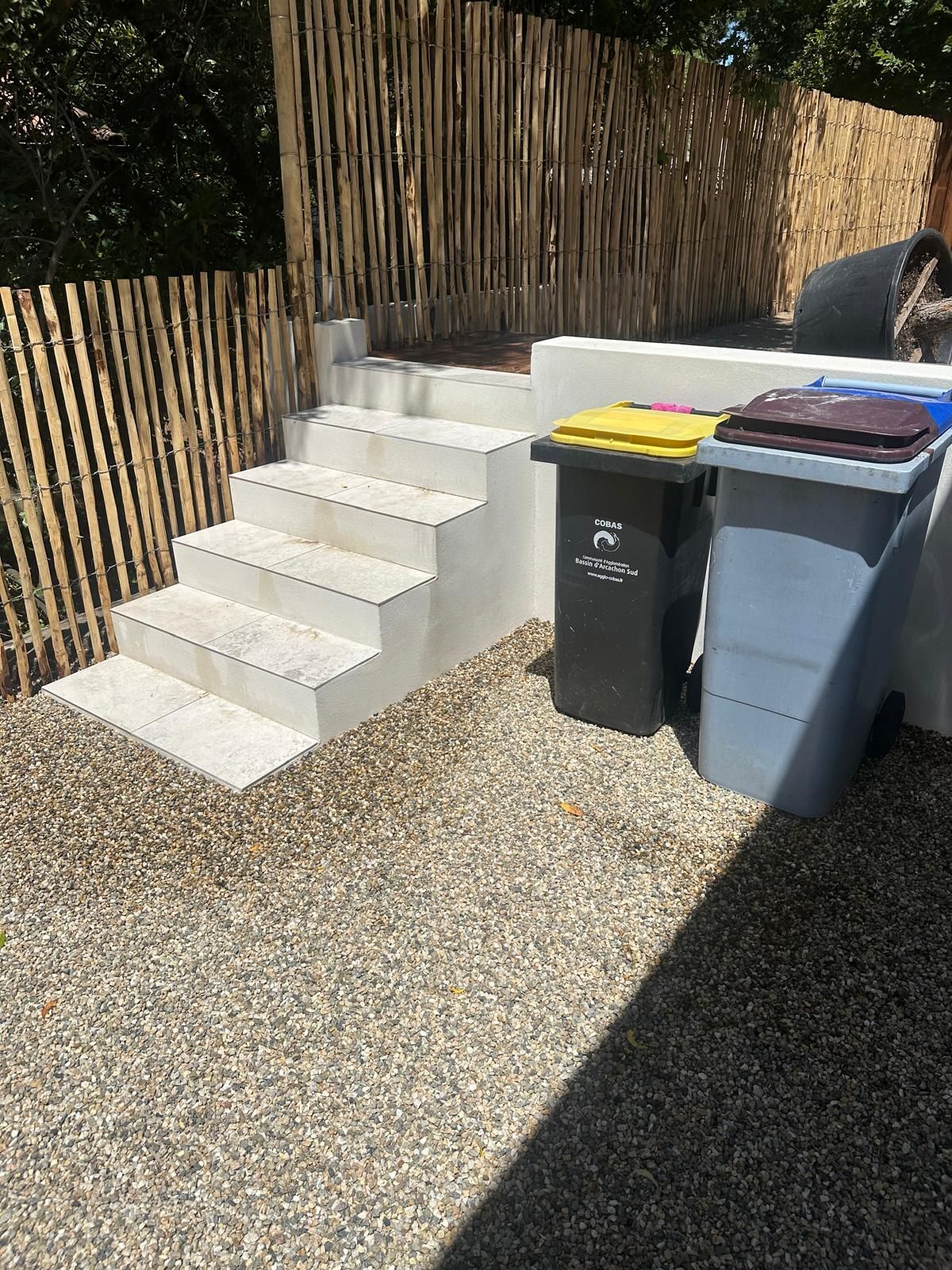Petit escalier extérieur avec deux poubelles
