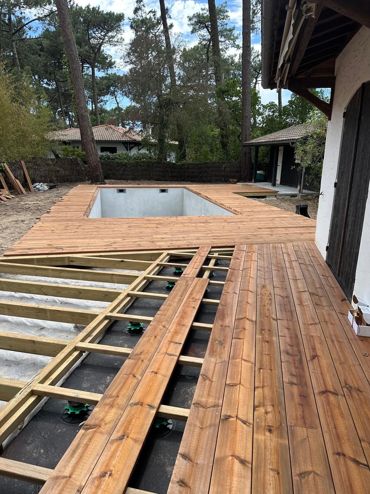 Plancher extérieur autour d'une piscine en cours de réalisation par une matinée ensoleillée