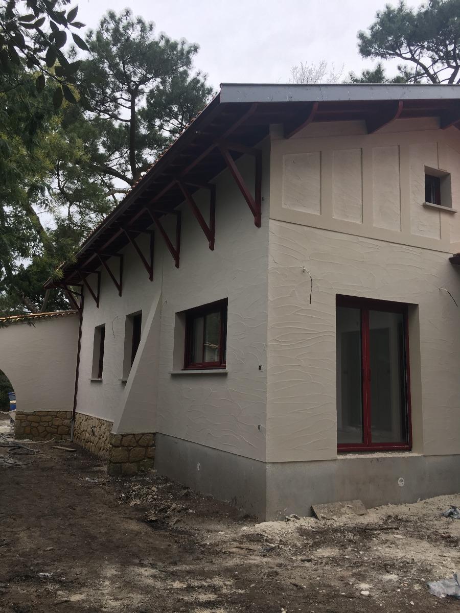 Façade d'une maison blanche en cours de rénovation 
