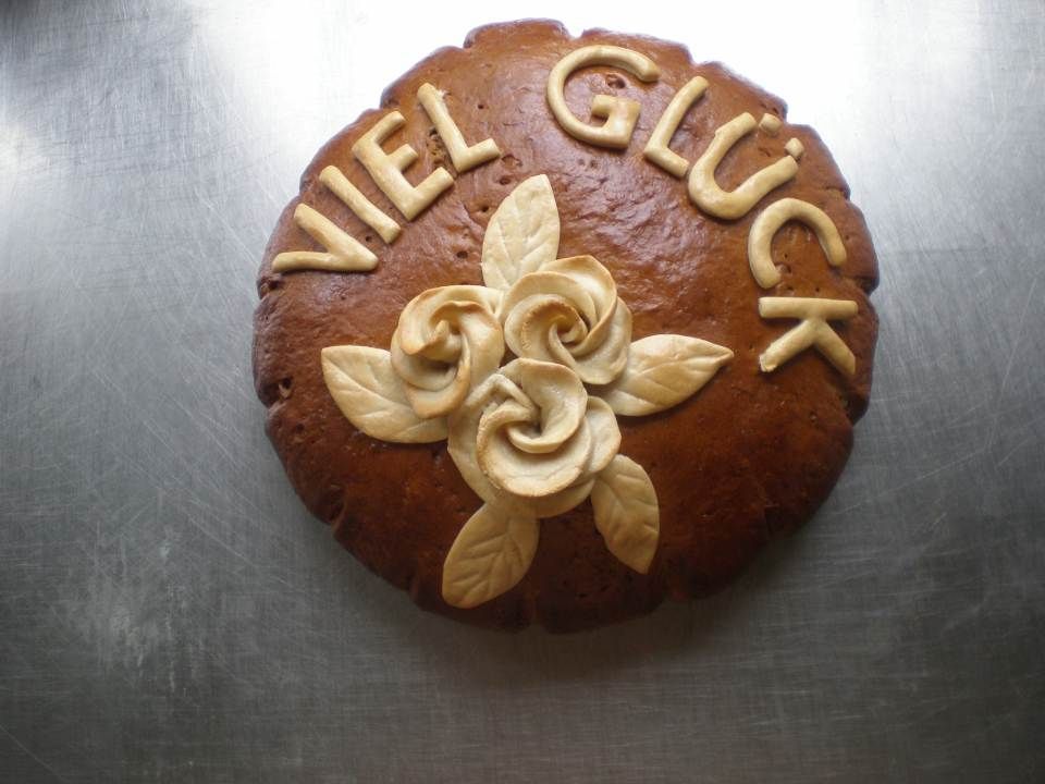 Bäckerei Bohse – ein großer, handgebackener Weihnachtsstollen mit unzähligen Rosinen liegt zur Präsentation auf einem Tisch mit roter Weihnachtsdekoration