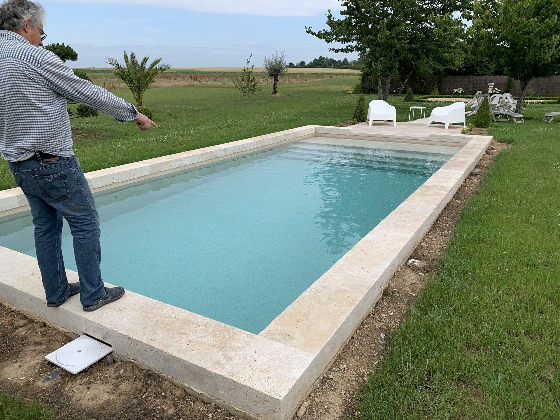 Une personne debout qui pointe du doigt quelque chose dans une piscine
