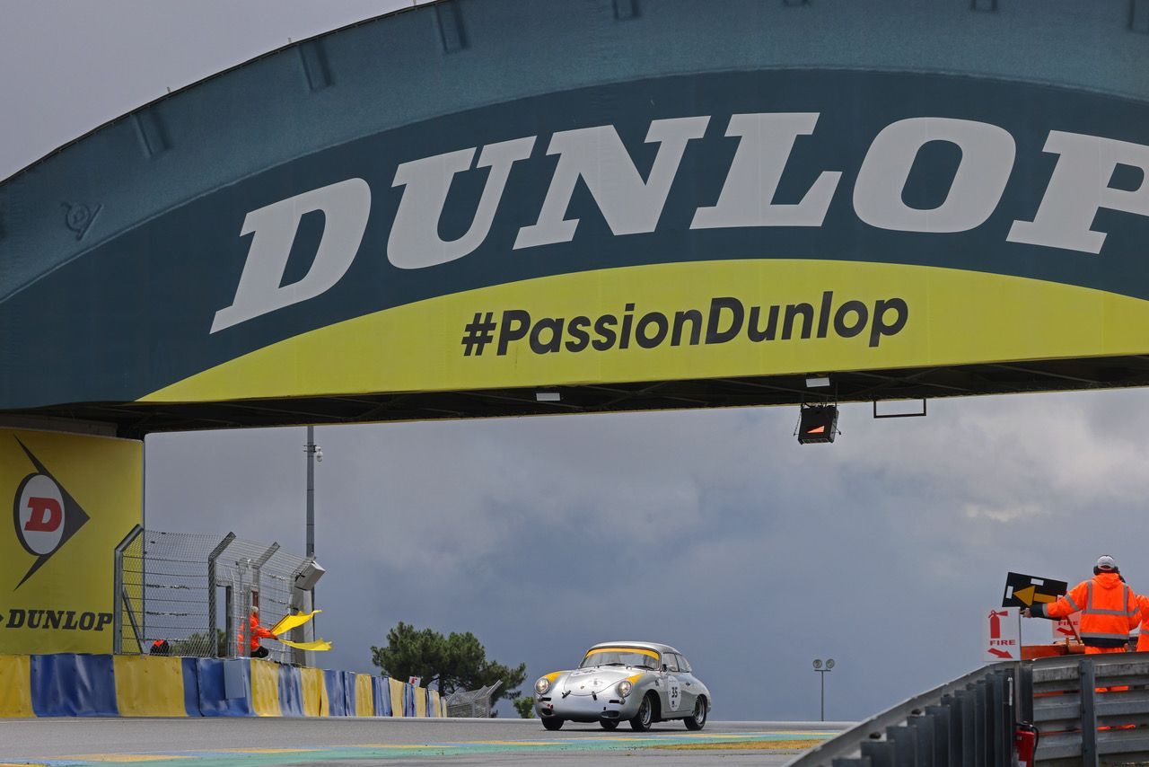 Vue d'une voiture qui passe sous une arche avec marqué Dunlop