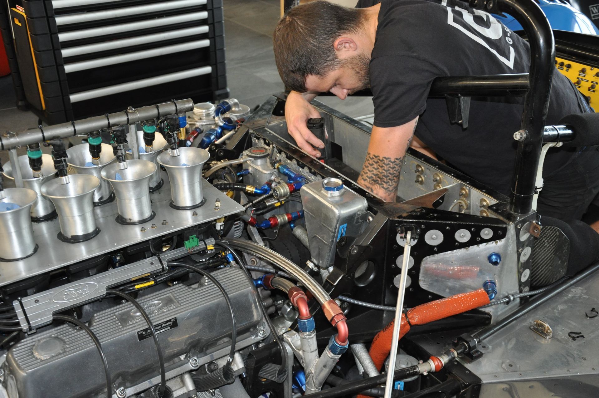 un mécanicien en train d'effectuer des réparations sur le moteur d'une voiture