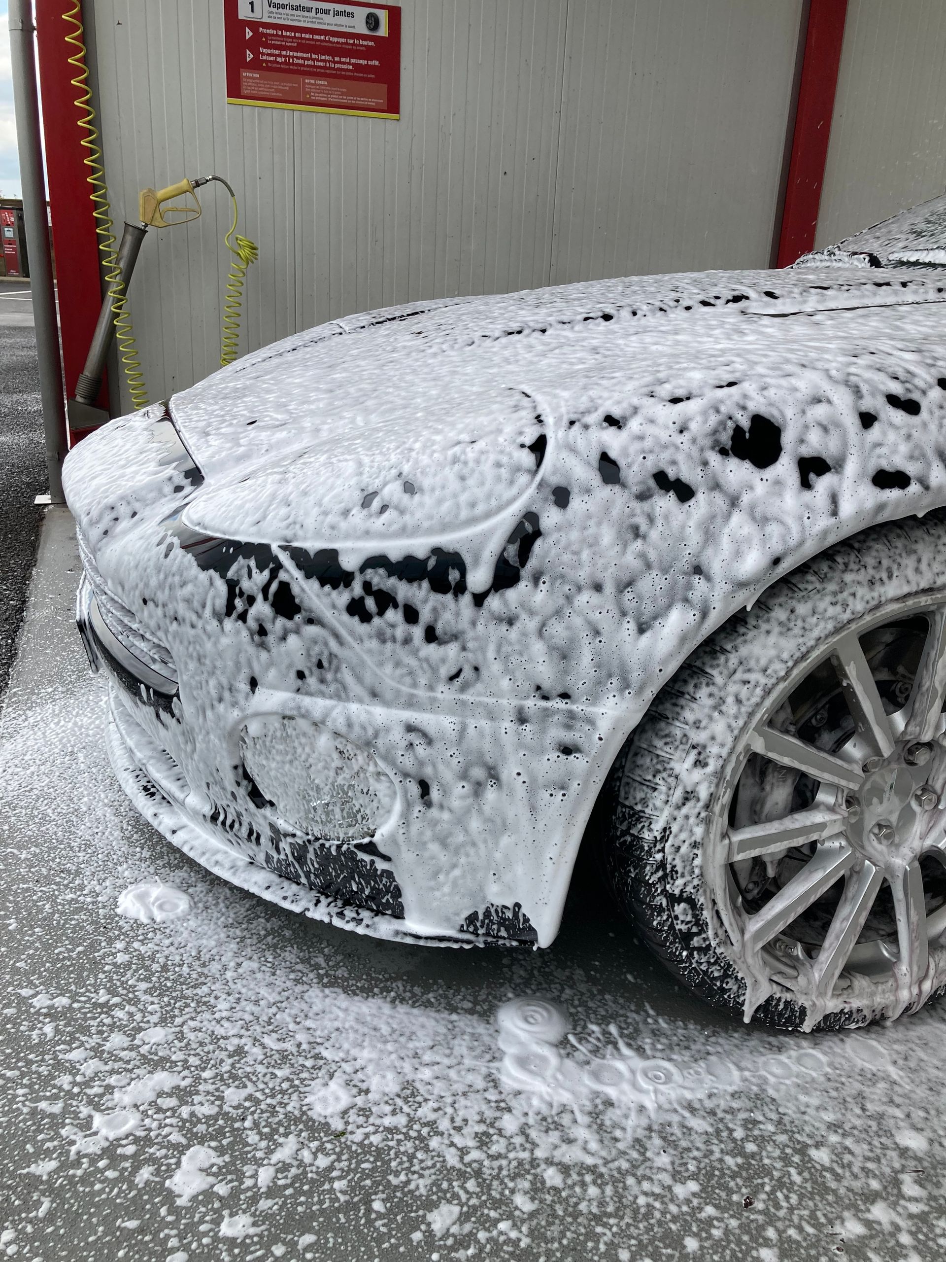 gros plan sur la carrosserie d'une voiture en train d'être lavé.